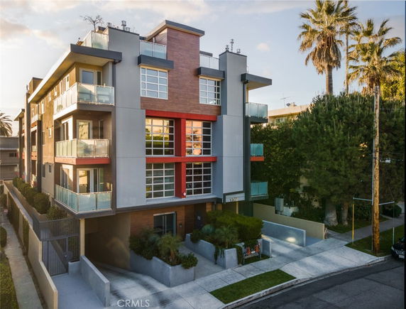 Front view of a modern multi-story apartment building with balconies.