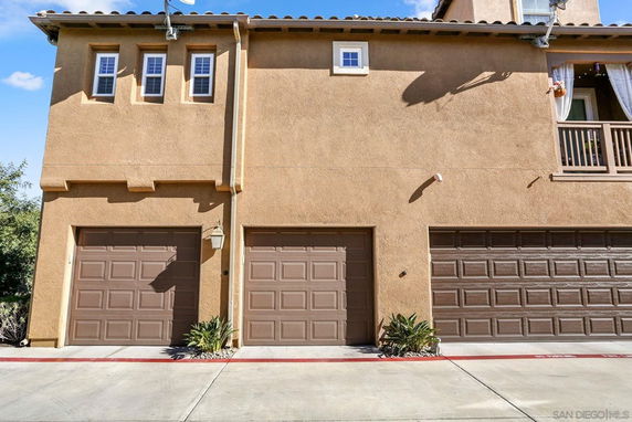 Front view of a multi-story building with garage doors.