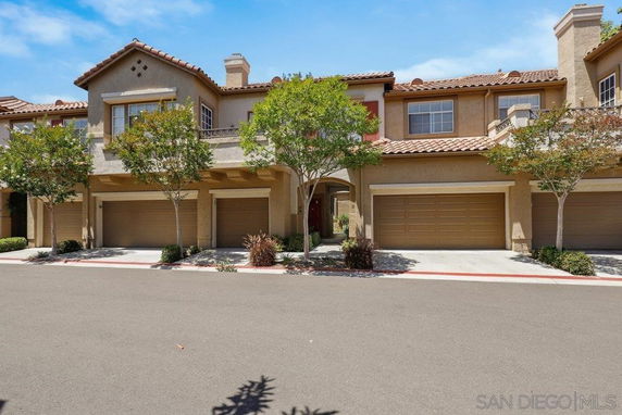 Front view of a two-story townhouse with a double garage and tile roof.