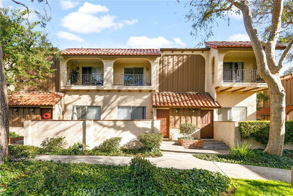 Front view of a two-story house with a tiled roof and balconies.