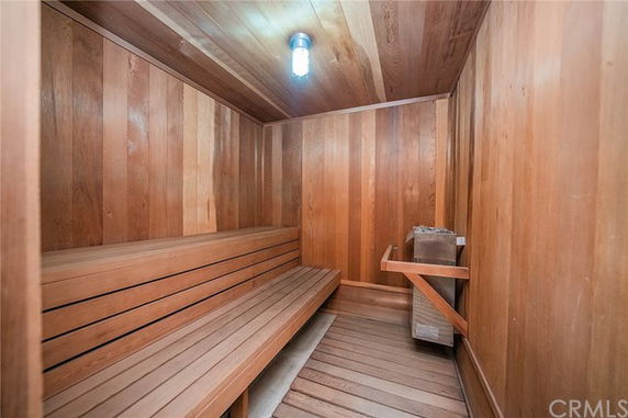 Interior view of a wooden sauna room with benches and a heating unit.