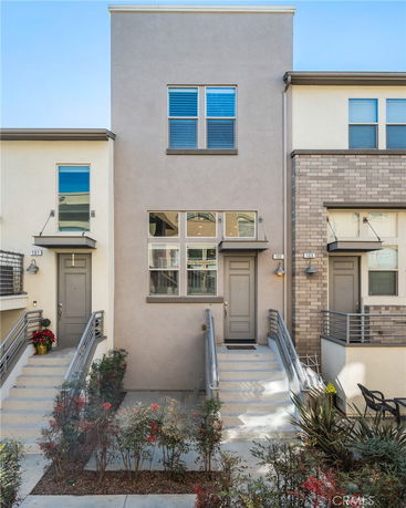 Front view of a multi-story townhouse with two entrances and connected stairways.
