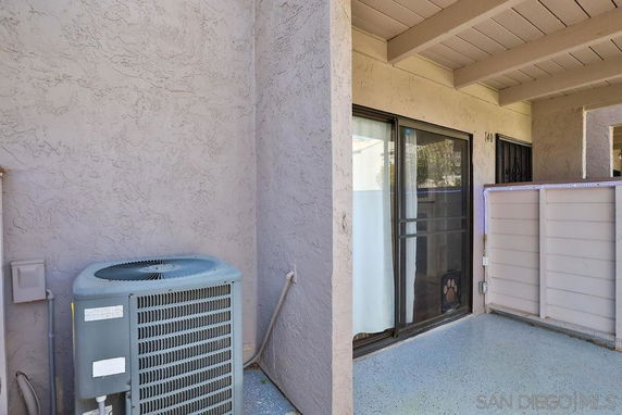 Rooftop area with an air conditioning unit and sliding glass door.