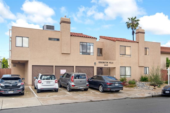 Front view of a two-story building with a flat roof and multiple garages.