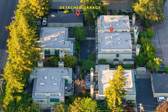 Aerial view of a residential complex with multiple flat-roofed buildings and a detached garage.