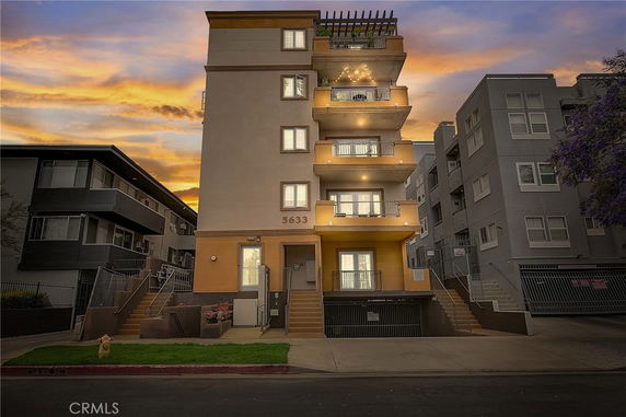 Front view of a multi-story apartment building with balconies.