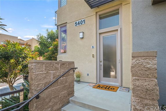 Entrance with a modern door and staircase leading up to it.