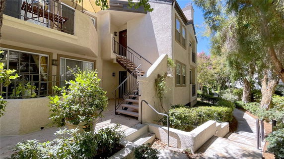 Front view of a two-story building with stairs leading to an upper-level entrance.