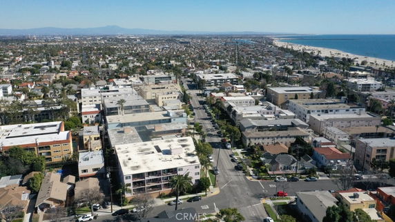 Wide angle view of a coastal cityscape with numerous buildings and a beach in the distance.