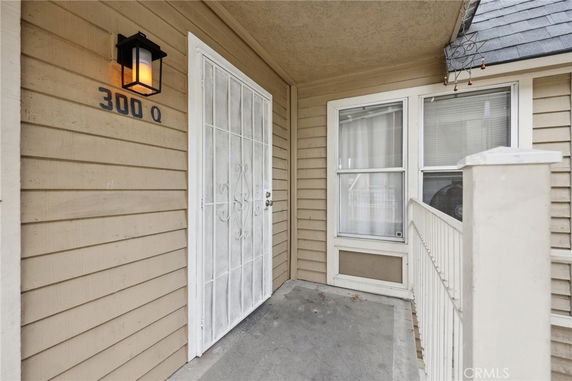 Front view of an entrance with a metal door and large windows.