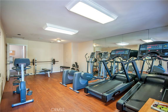 Indoor gym area with various exercise equipment including treadmills and stationary bikes.