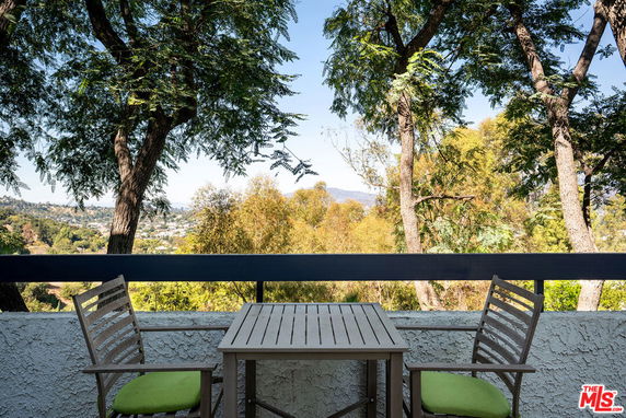 View of surrounding area from a balcony with table and chairs