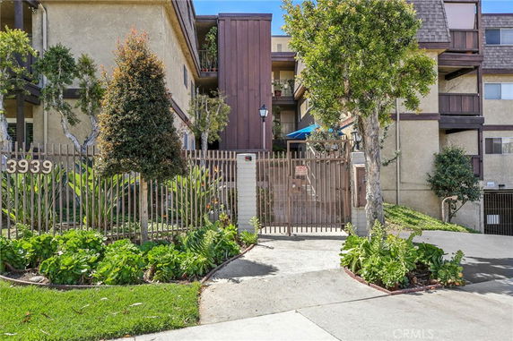 Front view of a multi-story residential building with entrance gate.