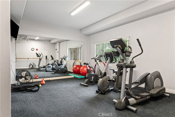 Indoor gym area with exercise equipment including treadmills and stationary bikes.