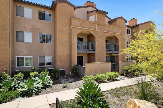 Front view of a multi-story apartment building with balconies.