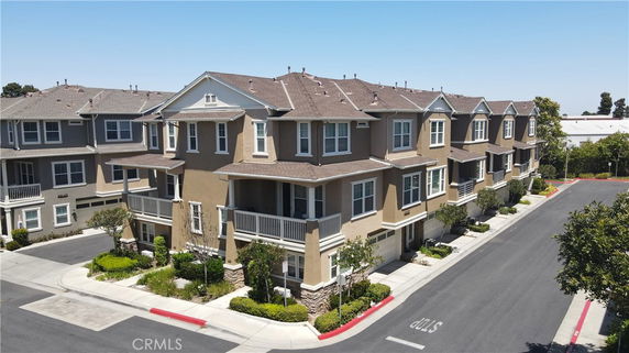 Front view of a multi-story residential building with balconies and garages.