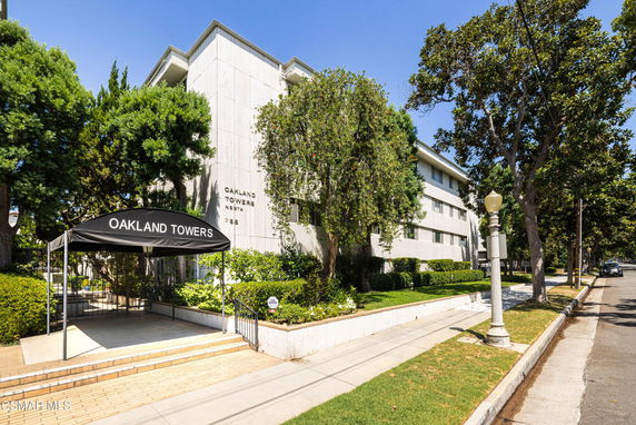 Front view of a multi-story building with the sign 'Oakland Towers North'.
