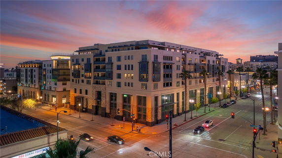 Exterior view of a multi-story building on a city street corner at dusk.