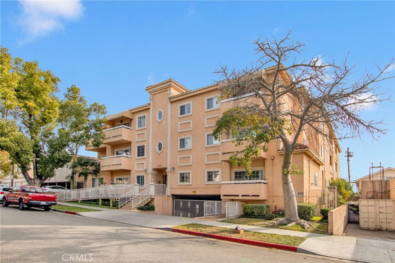 Front view of a multi-story apartment building with balconies.