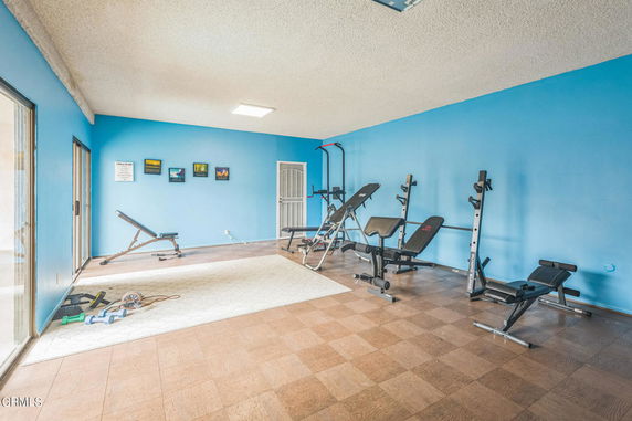 Indoor gym area with exercise equipment and blue walls.
