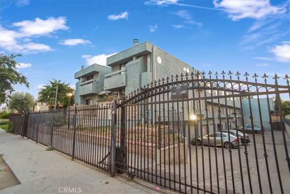 Front view of a multi-story residential building with gated entrance.