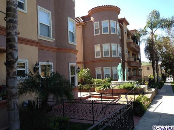 Front view of a multi-story residential building with a decorative façade and balconies.