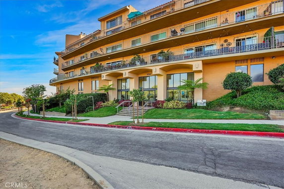 Front view of a multi-story residential building with balconies.