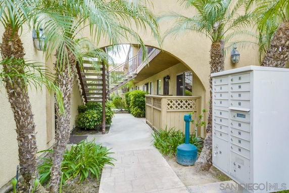 View of an exterior building walkway with stairs and mailboxes.