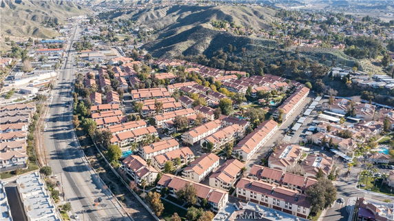 Aerial panoramic view of a neighborhood with rows of houses and surrounding hills.
