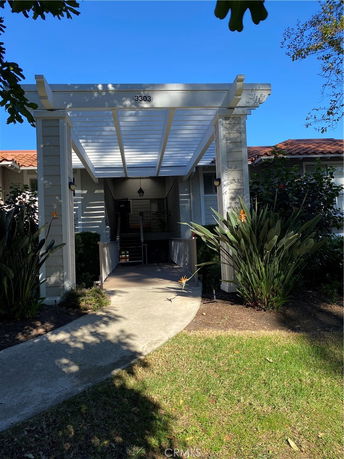 Front view of a house with a covered entrance and surrounding greenery.