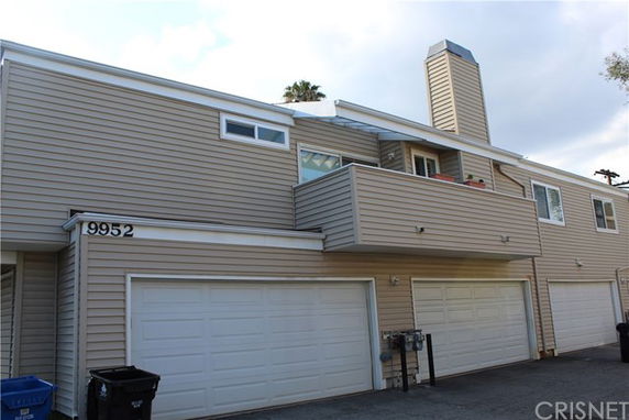Front view of a multi-story building with multiple garages.