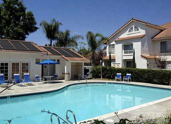 Outdoor swimming pool area with surrounding buildings.