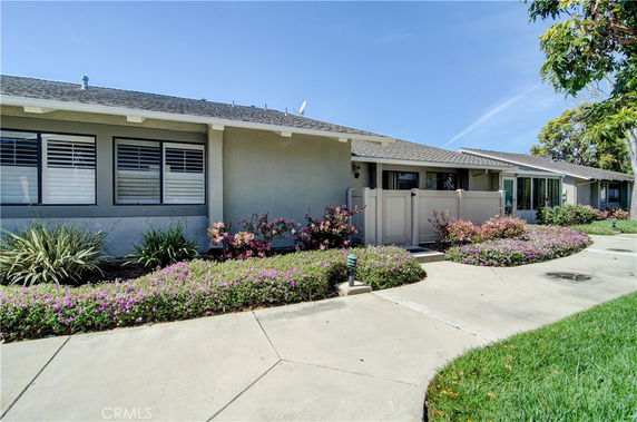 Front view of a single-story house with a small fenced patio.