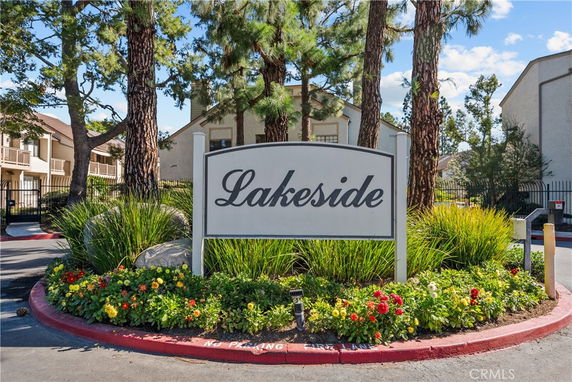 Front view of a residential building complex with a 'Lakeside' sign and landscaped entrance.