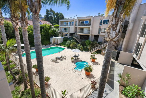 Outdoor area with a swimming pool and surrounding apartment buildings.