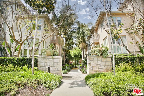 Front view of a residential building with two-story units and landscaped front area.