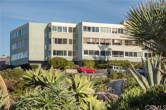 Front view of a multi-story building with large windows.