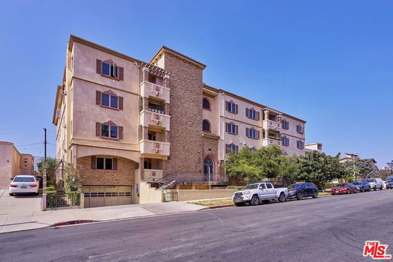 Front view of a multi-story apartment building with brick and stucco exterior.