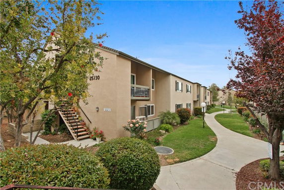 Front view of a multi-unit apartment building with two stories and external staircases.