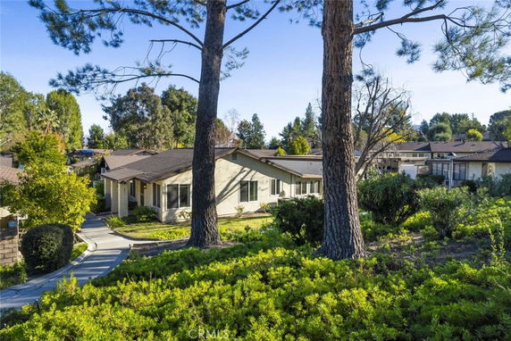 View of a house surrounded by trees and greenery.