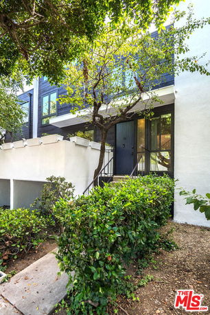 Front view of a modern two-story house with a staircase leading to the entrance.