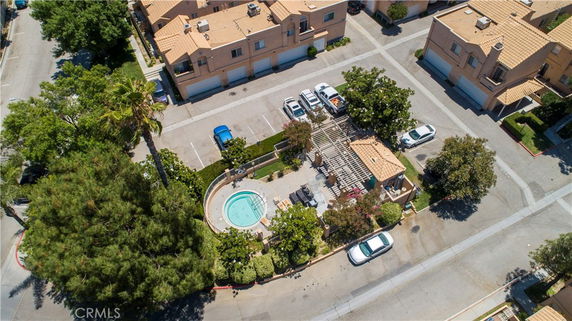 Aerial view of a residential complex with a central swimming pool area surrounded by buildings.