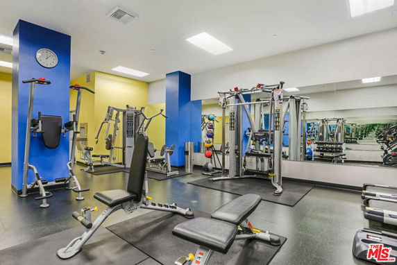Interior view of a gym with various exercise equipment and mirrors.