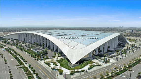View of a modern stadium with a distinctive curved roof.