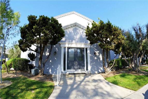 Front view of a single-story house with trees on either side