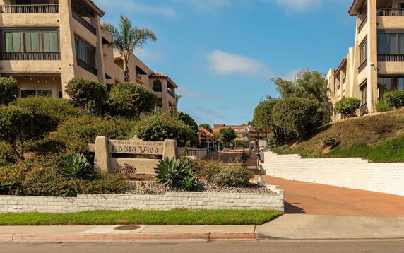 Front view of a multi-story residential complex with landscaping.