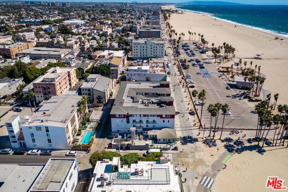 Aerial view of a coastal urban area with buildings and a nearby beach.