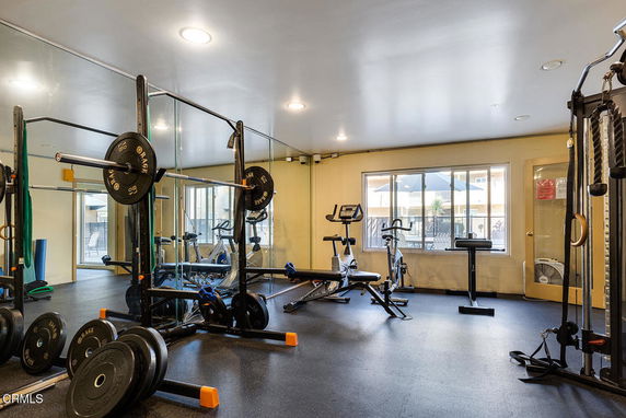 Indoor gym area with exercise equipment and mirrors.