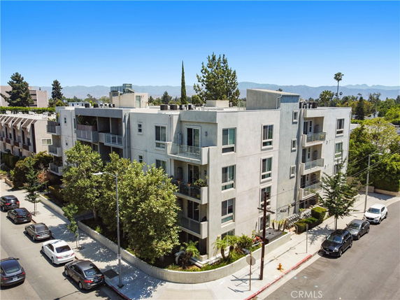 Front view of a multi-story apartment building with balconies and rooftop features.