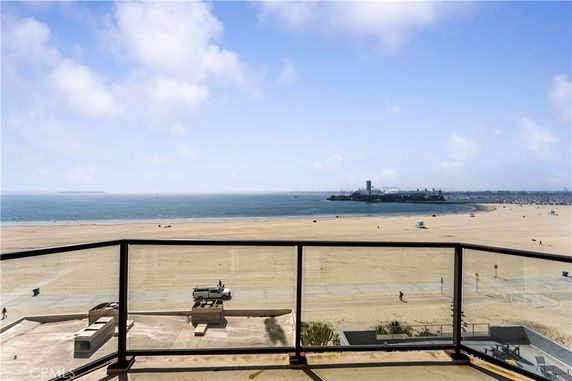 Wide angle view of the beach and ocean from a balcony.